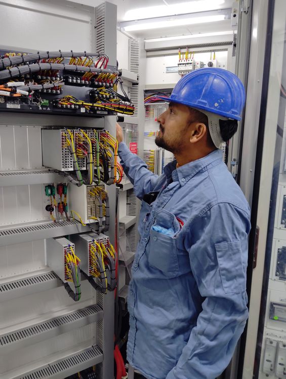 Ein Elektriker arbeitet konzentriert an der Verkabelung eines Schaltschranks.